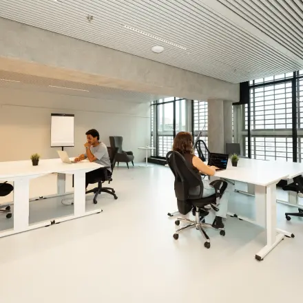 Moderne kantoorruimte huren in Den Haag Centrum aan de Waldopstraat 5, met strakke bureaus en ergonomische stoelen, waar zakelijke professionals gefocust werken in een lichte omgeving met grote ramen.
