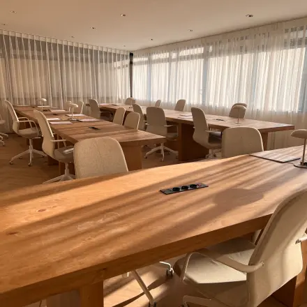Lichte en moderne kantoorruimte op Zeestraat 100 in Den Haag Centrum, met houten tafels en comfortabele stoelen, ideaal voor kantoorruimte huren.