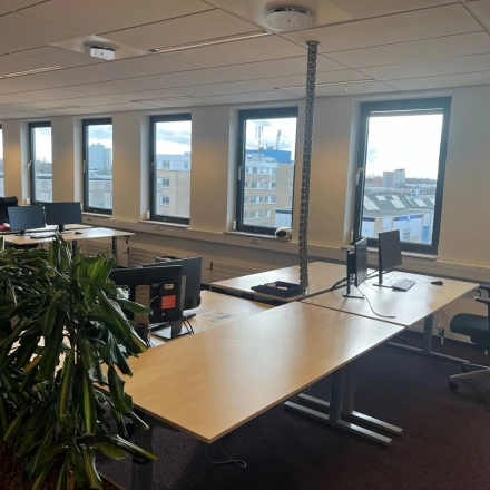 Lichte kantoorruimte met grote ramen en werkplekken aan de Platinaweg 10 in Den Haag Escamp, ideaal voor kantoorruimte huren met een modern interieur en uitzicht op de stad.