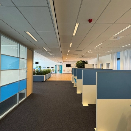 Moderne kantoorruimte aan Platinaweg 10, Den Haag Escamp met werkplekken, glazen wanden en blauwe accenten. Ideaal voor bedrijven die kantoorruimte zoeken. 