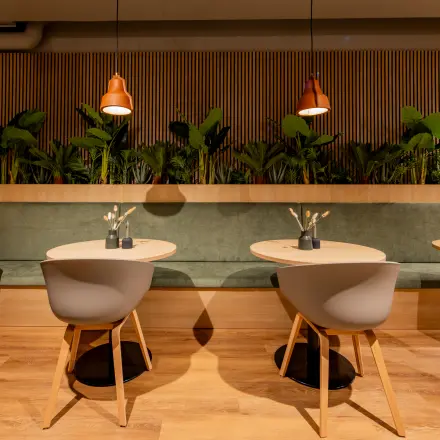 Modern ingerichte kantoorruimte op Diemerhof 42, Diemen met stijlvolle zitjes en houten details. Ideaal voor wie een kantoorpand zoekt om te huren. Groene elementen accentueren de warme sfeer.