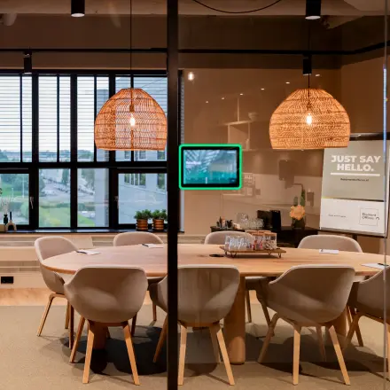 Vergaderruimte in Diemerhof 42, Diemen, met een grote houten tafel omringd door moderne stoelen en hanglampen boven de tafel.