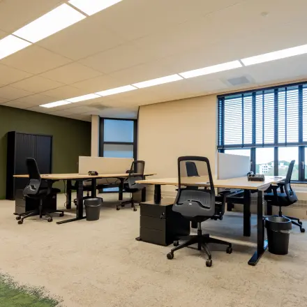 Kantoorruimte huren bij Diemerhof 42 in Diemen. Moderne werkplek met meerdere bureaus, comfortabele stoelen en veel natuurlijk licht door grote ramen, ideaal voor effectief werken.
