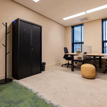 Moderne kantoorruimte huren op Diemerhof 42 in Diemen met twee bureaus, stoelen, een opbergkast en accessoires voor een functionele werkplek.