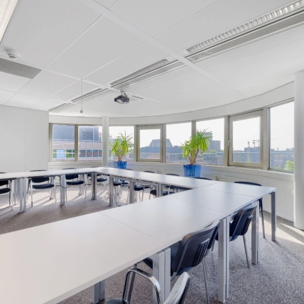 Lichte kantoorpand op Wisselwerking 40-48 in Diemen met grote ramen, witte tafels en stoelen. Ruime opzet ideaal voor kantoorruimte huren met prachtig uitzicht.