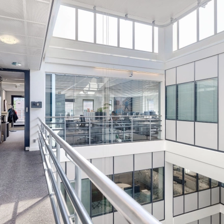 Lichte en moderne kantoorruimte op Wisselwerking 40-48, Diemen, met een open vloerplan en veel ramen. Personen voeren zakelijke gesprekken terwijl ze door het gebouw lopen.