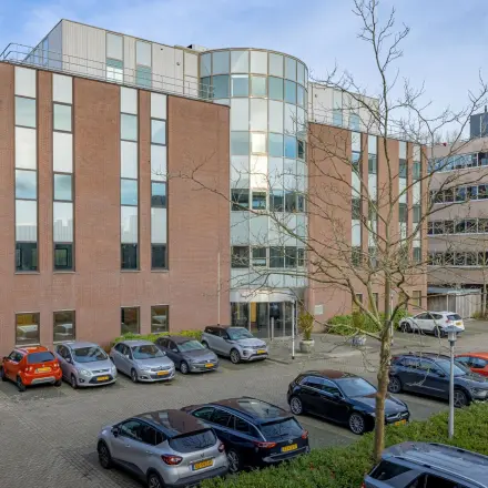 Exterieur van het kantoorpand Wisselwerking 40-48 te Diemen, met meerdere geparkeerde auto's op de voorgrond. Kantoorruimte huren in een modern, veelzijdig gebouw.