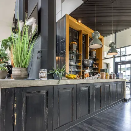 Sfeervolle kantoorruimte huren op Luchthavenweg 81, Eindhoven Airport, met een gezellige ontvangstruimte en stijlvolle bar. Perfecte locatie voor zakelijke ontmoetingen en netwerkkansen in een moderne kantoorpandomgeving.