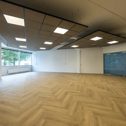 Ruime, lichte kantoorruimte te huur op Luchthavenweg 81, Eindhoven Airport, met modern houten vloerontwerp en grote ramen voor veel natuurlijk licht.