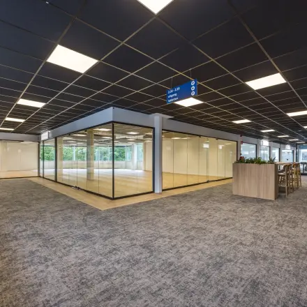 Moderne kantoorruimte huren op Eindhoven Airport, gelegen aan Luchthavenweg 81. Het kantoorpand heeft ruime werkplekken met veel glaswanden voor natuurlijk licht.