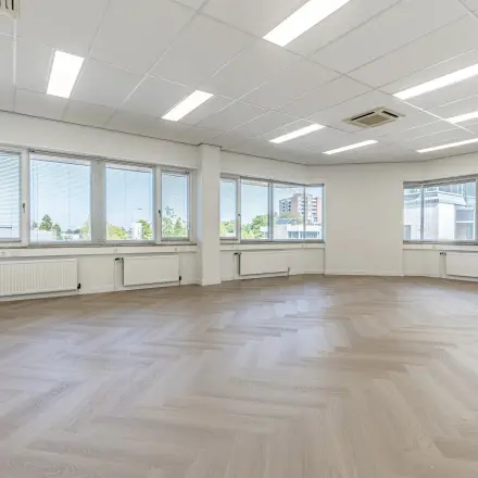 Ruime, lichte kantoorruimte met grote ramen en een visgraatvloer, ideaal voor huren in een kantoorpand op Croy 7, Eindhoven De Hurk.
