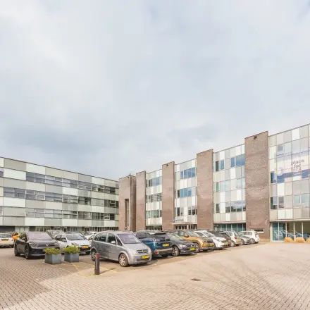 Kantoorpand op Hurksestraat 60 in Eindhoven De Hurk met parkeerplaats vol auto's. Ideaal voor wie kantoorruimte wil huren in een zakelijke omgeving.