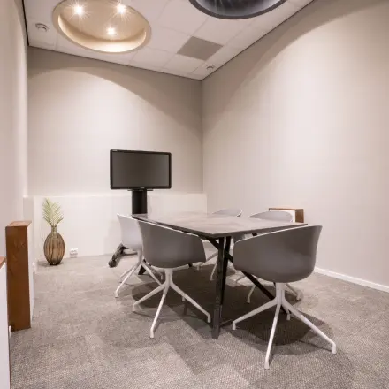 Stijlvolle vergaderruimte te huur in kantoorpand Torenallee 20, Eindhoven Strijp-S, met moderne meubels en presentatiescherm.