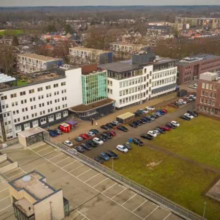 Luchtfoto van het kantoorpand aan de Brouwerijstraat 1 in Enschede met parkeergelegenheid ervoor. Het gebouw is ruim opgezet en biedt mogelijkheden voor kantoorruimte huren.