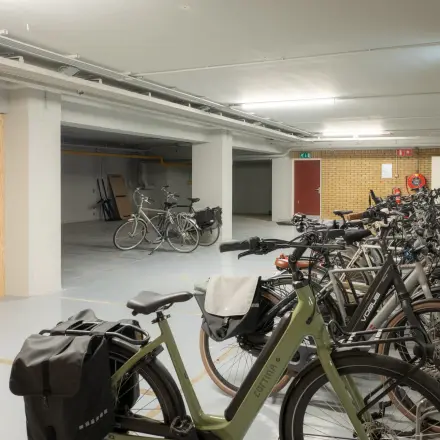 Fietsenstalling in het kantoorpand op Kuipersdijk 2-4 in Enschede, met diverse fietsen geparkeerd tegen een muur. Ideale faciliteit bij het kantoorruimte huren.