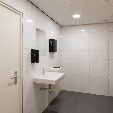 Kantoorruimte huren aan Kuipersdijk 2-4 in Enschede met een nette toiletruimte voorzien van witte tegels, wastafel en urinoirs. Ideaal voor kantoorpand dat hygiëne hoog in het vaandel heeft.