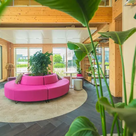 Moderne kantoorruimte huren op Moutlaan 1-23 in Enschede, met houten interieur en kleurrijke zithoek. Geschikt voor huur voor diverse zakelijke activiteiten.
