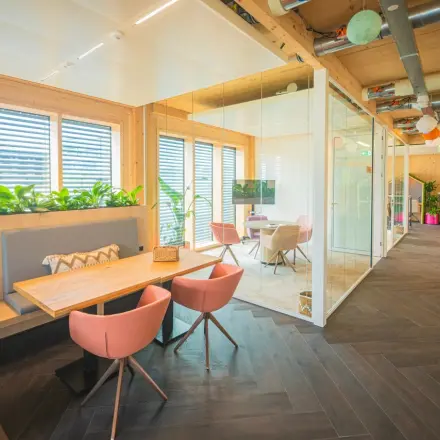 Moderne kantoorruimte in Enschede met glazen wanden, houten details en stijlvolle meubels biedt lichte en inspirerende werkplekken. Ideaal om te huren voor een professioneel en aangenaam kantoorpand.