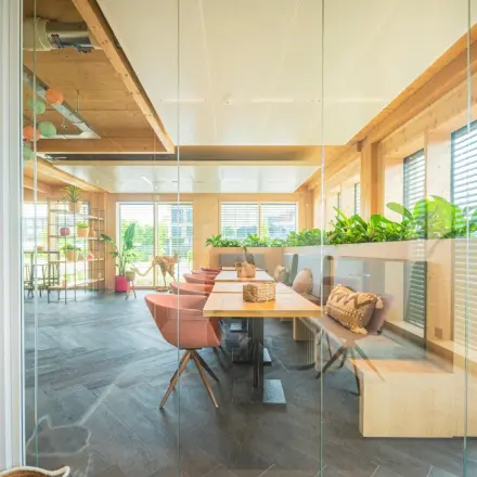 Licht en modern ingerichte kantoorruimte met houten accenten en planten aan Moutlaan 1-23, Enschede. Ideaal voor wie op zoek is naar een inspirerend kantoor om te huren.