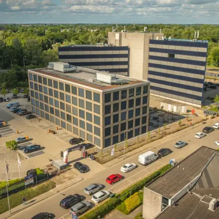 Buitenzicht van een modern kantoorpand op Moutlaan 1-23 in Enschede, ideaal voor bedrijven die kantoorruimte willen huren. Het gebouw is omgeven door voldoende parkeergelegenheid.