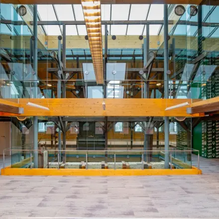 Moderne kantoorruimte met glazen wanden en houten balken op Prins Hendrikkade 3 in Franeker, ideaal voor wie kantoorruimte wil huren.