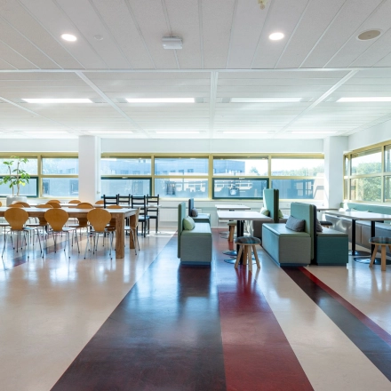 Ruime kantoorruimte te huur op Groningenweg 8 8 in Gouda met grote ramen, moderne meubels en veel natuurlijk licht, ideaal voor werk of vergaderingen.