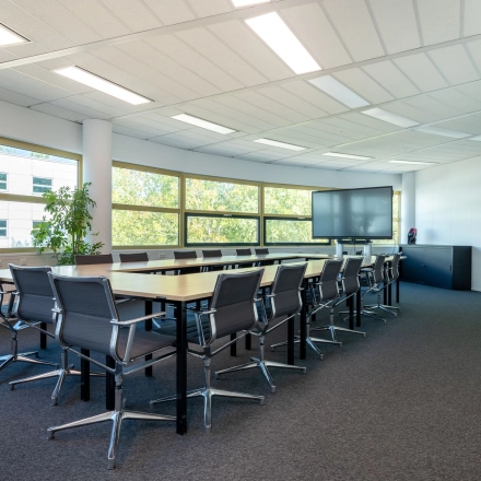 Kantoorruimte huren in Gouda met grote vergadertafel, comfortabele stoelen en veel daglicht aan Groningenweg 8 8. Het kantoorpand biedt een professionele omgeving, ideaal voor vergaderingen of teamwerk.