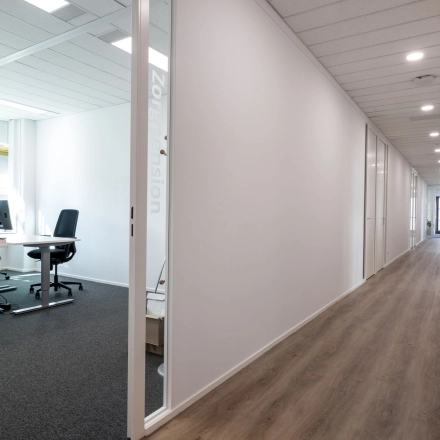 Moderne kantoorruimte in Gouda met glazen deur en een lichte werkplek met bureau en computerschermen, gelegen aan Groningenweg 8 8.