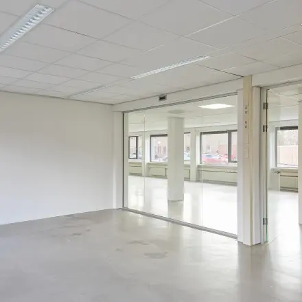 Lichte, open kantoorruimte te huur op de Schweitzerlaan 12 in Groningen met glazen wanden en veel natuurlijk licht.