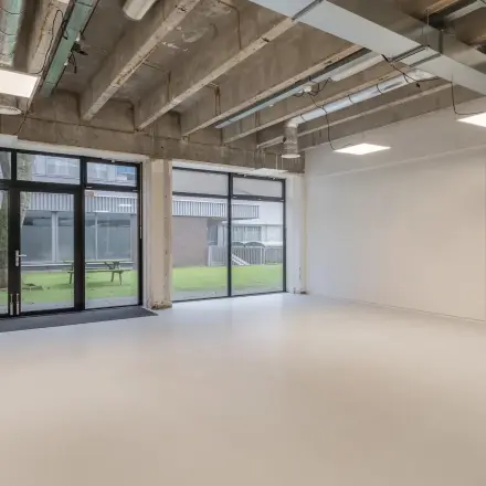 Ruime kantoorruimte te huur met grote ramen en zicht op groene buitenruimte aan de A. Hofmanweg 5A, Haarlem Waarderpolder. Ideaal voor creatieve kantoren met een industriële uitstraling.