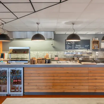 Modern ingerichte kantoorruimte huren op A. Hofmanweg 5A, Haarlem Waarderpolder, met een stijlvolle pantry met industriële lampen en houten afwerking.