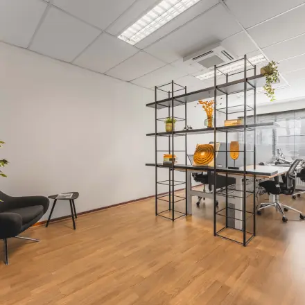 Moderne kantoorpand ruimte met houten vloer, werkplekken en decoratieve planten. Ideaal voor kantoorruimte huren aan de Steenovenweg 5 in Helmond.