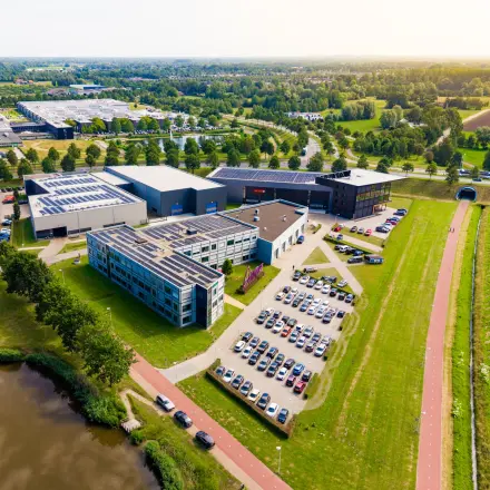 Luchtfoto van het kantoorpand aan de Jan Tinbergenstraat 202 in Hengelo, omringd door groen en parkeerplaatsen. Ideale locatie voor kantoorruimte huren.
