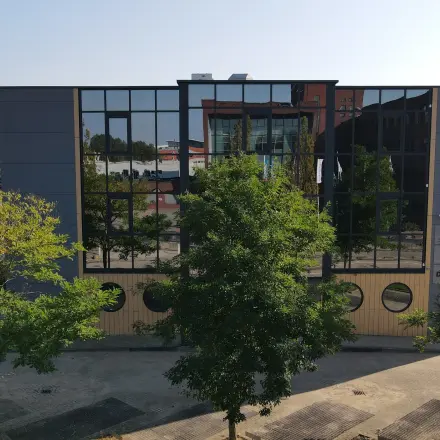 Kantoorpand aan Catharina van Renneslaan 8-10 in Hilversum met moderne gevel en spiegelende ramen, geschikt voor kantoorruimte huren.