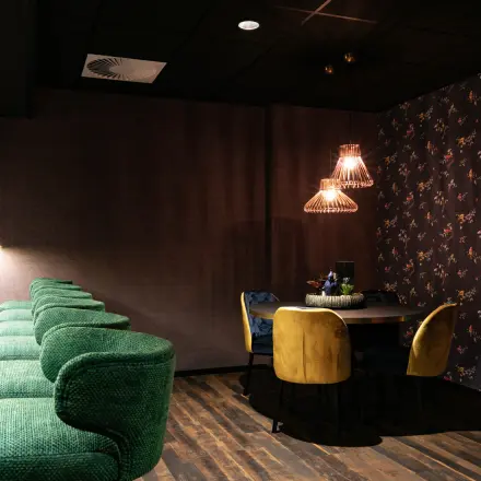 Stijlvolle kantoorruimte op Steijnlaan 16 in Hilversum met luxe groene barkrukken en een gezellige zithoek met gele stoelen.