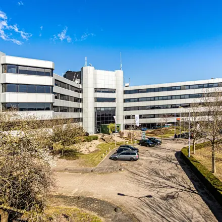 Modern kantoorpand aan de Hoeksteen 54-72 in Hoofddorp met een ruime parkeerplaats en opvallende architectuur.