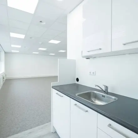 Heldere kantoorruimte met witgeklede muren en een kleine pantry bij Polarisavenue 130-150 in Hoofddorp, ideaal voor kantoorruimte huren.
