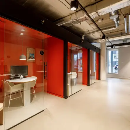 Moderne kantoorruimte te huur in Hoofddorp, met glazen wanden en een industriële uitstraling. Geschikt voor zakelijke activiteiten in een open floorplan kantoorpand.