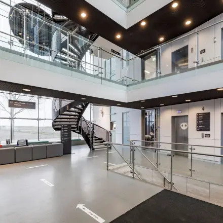 Moderne entree van een kantoorpand op Siriusdreef 16 in Hoofddorp met loungeset en liften. Perfect voor bedrijven die kantoorruimte willen huren.