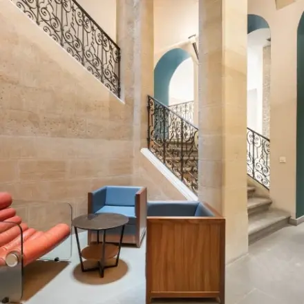 Stijlvolle kantoorruimte huren op Siriusdreef 17, Hoofddorp met designstoelen, houten tafels en een prachtig trapontwerp.