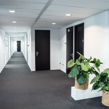 Lichte gang in kantoorpand Meidoornkade 22 in Houten met planten langs de muur, ideaal voor kantoorruimte huren.