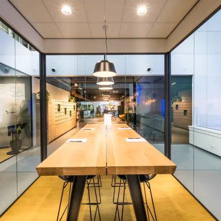 Moderne vergaderruimte in kantoorpand op Bargelaan 200, Leiden, met lange houten tafel en designstoelen, ideaal voor kantoorruimte huren.