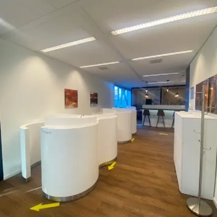 Moderne kantoorruimte met houten vloer en witte meubels, geschikt voor zakelijke activiteiten in kantoorpand op Mendelweg 30, Leiden. Ideaal voor wie een kantoorruimte wil huren.