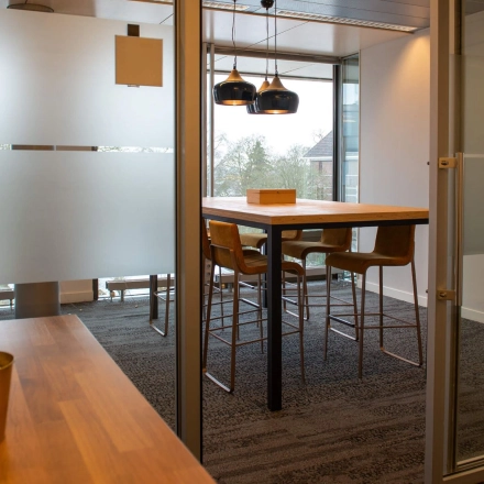 Een gemeubileerd kantoor op Blankenstein 400 in Meppel, met moderne hoge tafels en stoelen, geschikt voor zakelijke besprekingen of als werkruimte. Ideale kantoorruimte huren voor creatieve samenwerkingen.