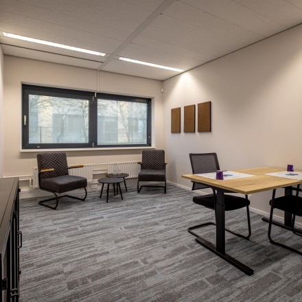 Gezellige kantoorruimte huren op Gooimeer 1 in Naarden, met twee bureaus, comfortabele stoelen en raam met veel daglicht.