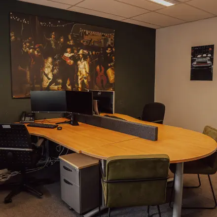 Gemeubileerde kantoorruimte met een grote houten tafel, bureaustoelen en twee beeldschermen, gelegen op Abdis van Thornstraat 74 in Oosterhout Nb.
