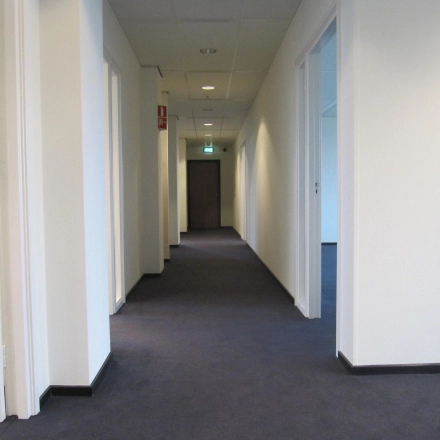 Neutrale gang in een kantoorpand op JC van Markenlaan 3, Rijswijk, met diverse deuren naar kantoorruimtes. Ideaal als je kantoorruimte wil huren in een rustige omgeving.