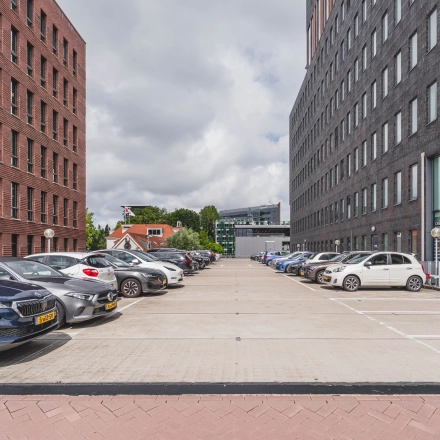 Parkeerplaats voor het kantoorpand op Laan van Zuid Hoorn 70, Rijswijk, met diverse geparkeerde auto's en omringende kantoorgebouwen.
