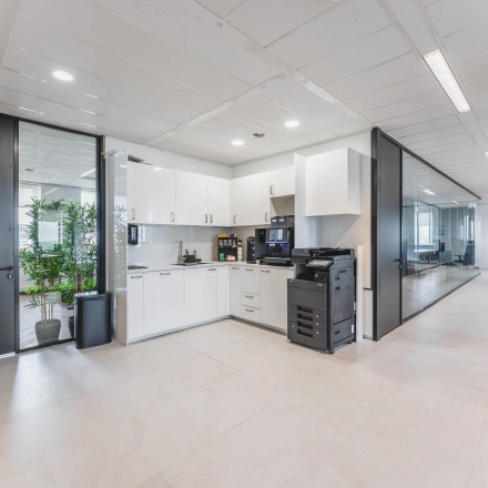 Moderne kantoorruimte aan de Laan van Zuid Hoorn 70 in Rijswijk, met een gemeubileerde pantry en glazen wanden voor een open sfeer. Ideale ruimte om te huren voor diverse kantooractiviteiten.