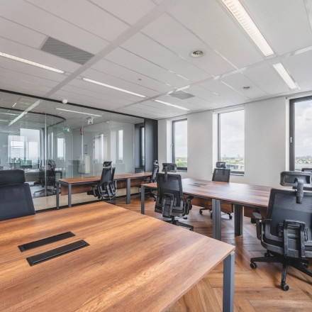 Kantoorruimte op Laan van Zuid Hoorn 70 in Rijswijk met grote ramen, houten bureaus en ergonomische stoelen, ideaal voor werkplekken.